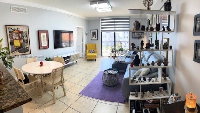 dining area with tile patterned flooring, visible vents, and crown molding