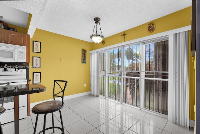 tiled dining area with a textured ceiling