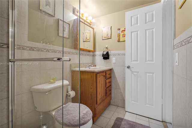 bathroom with tile patterned flooring, vanity, toilet, and tile walls