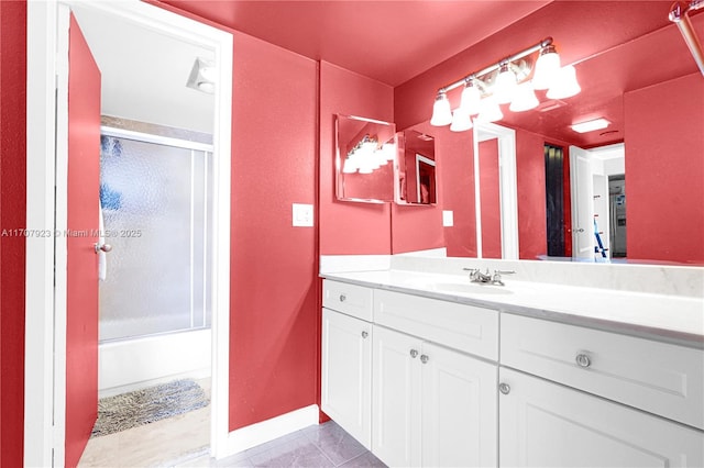 bathroom with tile patterned flooring, vanity, and bath / shower combo with glass door