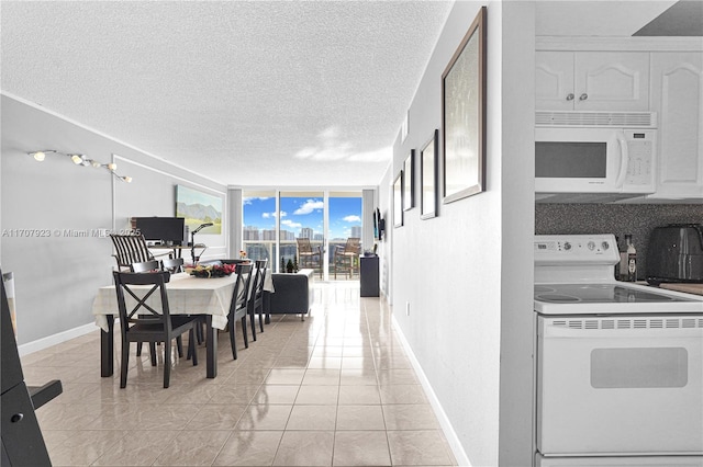 dining room featuring a wall of windows, a textured ceiling, and light tile patterned floors