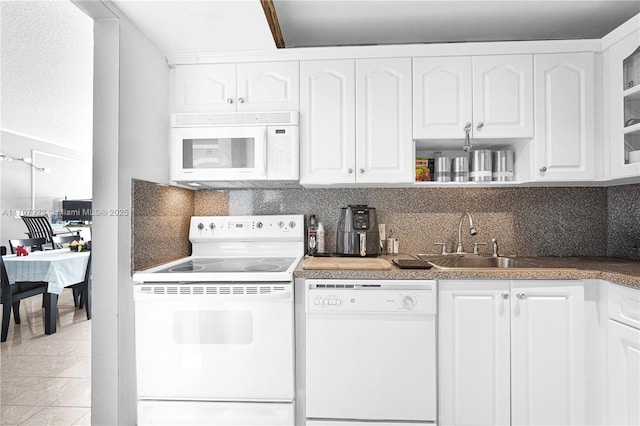 kitchen featuring sink, backsplash, white cabinets, and white appliances