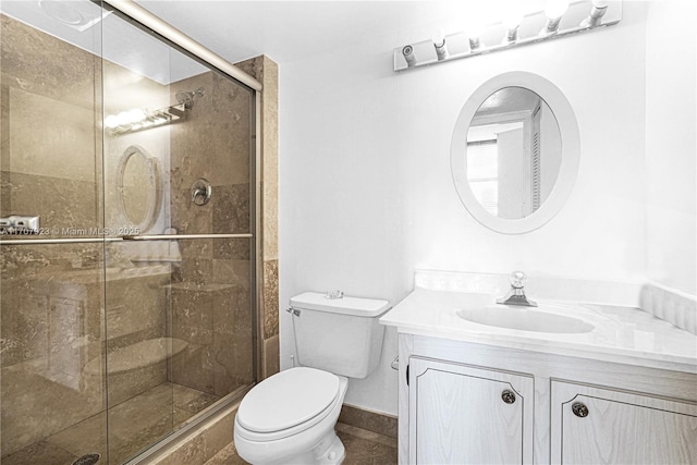 bathroom featuring vanity, toilet, and an enclosed shower