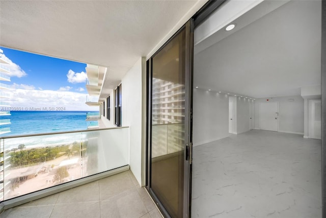 balcony with a water view and a beach view