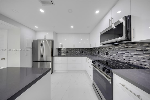 kitchen featuring white cabinets, stainless steel appliances, and tasteful backsplash