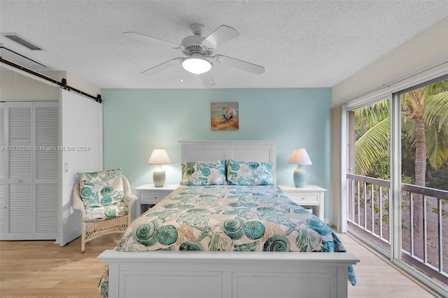 bedroom featuring light hardwood / wood-style flooring, ceiling fan, access to exterior, a textured ceiling, and a closet