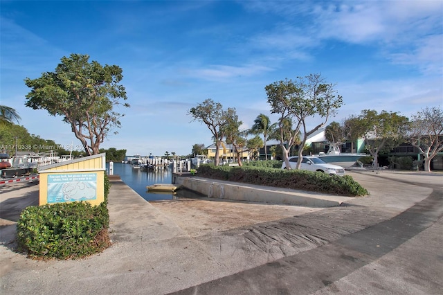 view of property's community with a water view and a dock