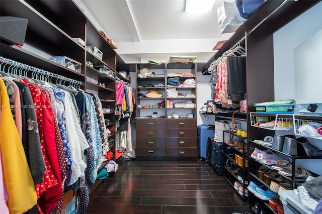 walk in closet with dark wood-type flooring