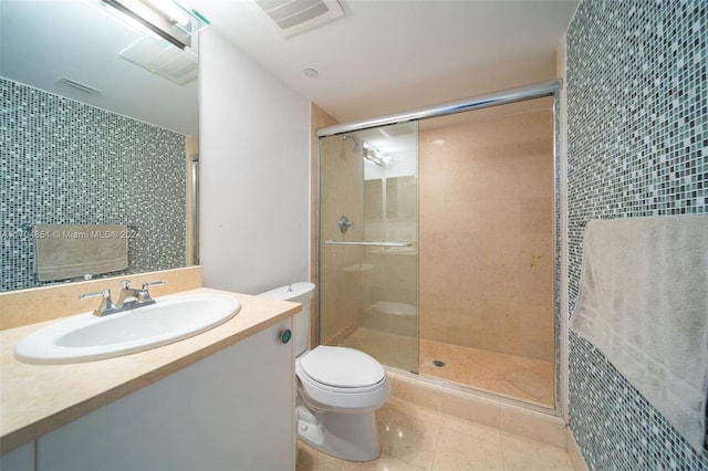 bathroom featuring tile patterned floors, vanity, toilet, and a shower with door