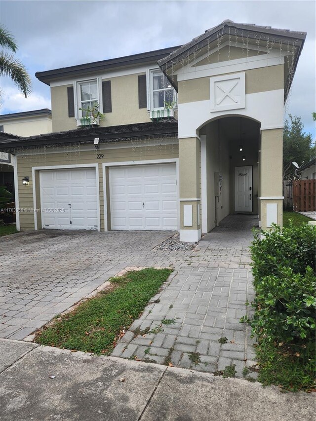 229 NE 36th Ter, Homestead, FL 33033 - view of front facade featuring a garage, stucco siding, and decorative driveway