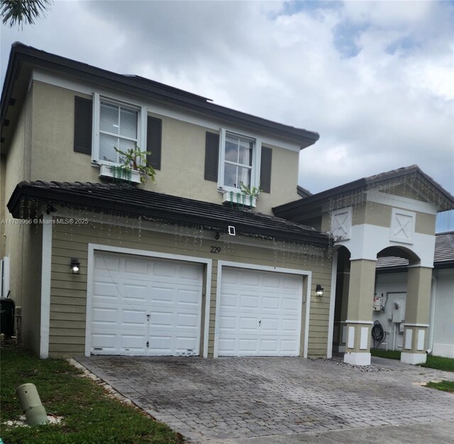 229 NE 36th Ter, Homestead, FL 33033 - view of front of house featuring decorative driveway, an attached garage, and stucco siding