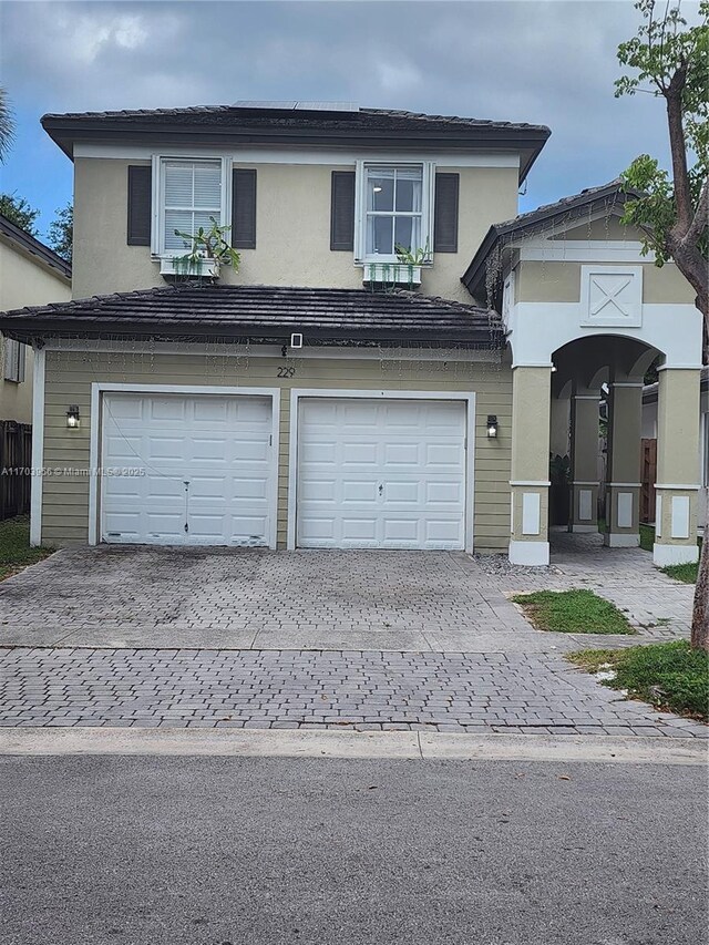 229 NE 36th Ter, Homestead, FL 33033 - traditional home with an attached garage, decorative driveway, and stucco siding