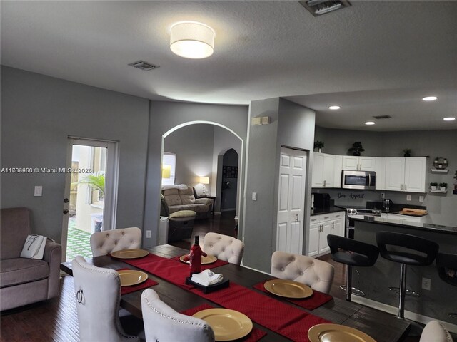 229 NE 36th Ter, Homestead, FL 33033 - dining area featuring arched walkways, dark wood finished floors, and recessed lighting