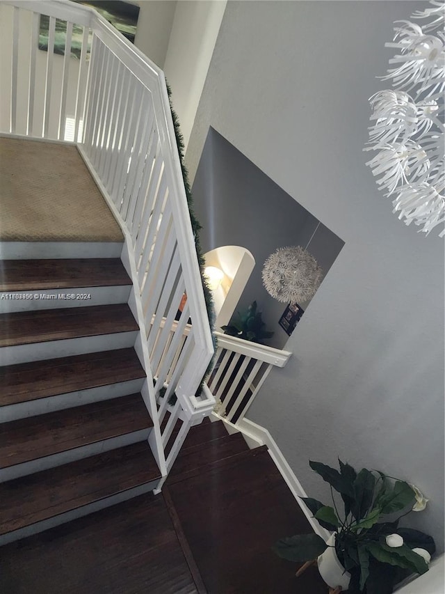 staircase with a notable chandelier