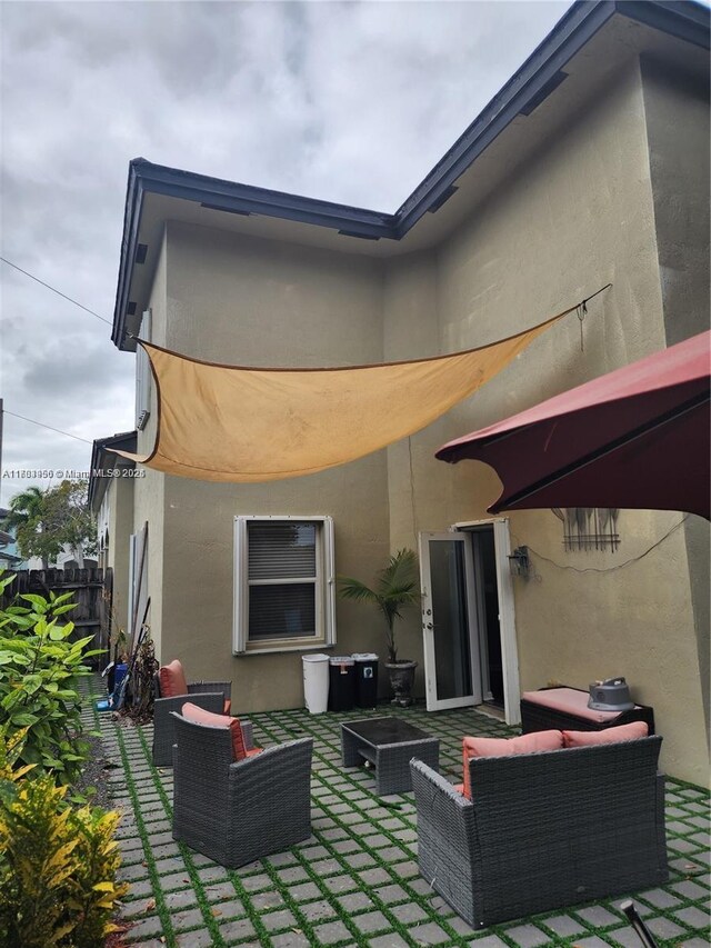 229 NE 36th Ter, Homestead, FL 33033 - rear view of property featuring stucco siding, an outdoor hangout area, and a patio area