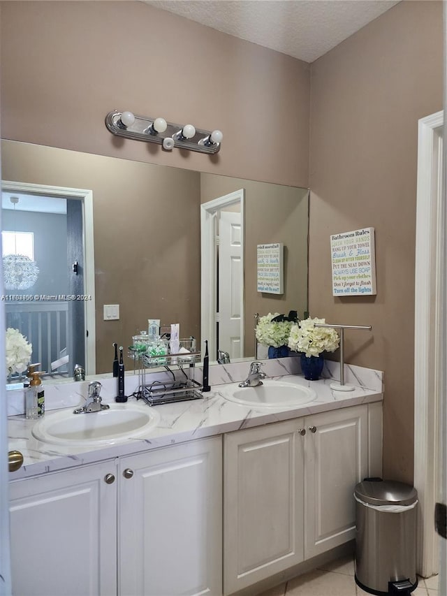 bathroom with tile patterned flooring, vanity, and a textured ceiling