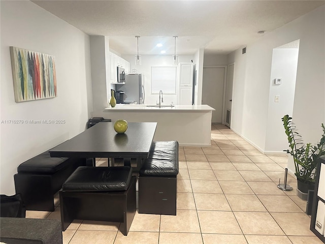 dining area featuring sink and light tile patterned floors