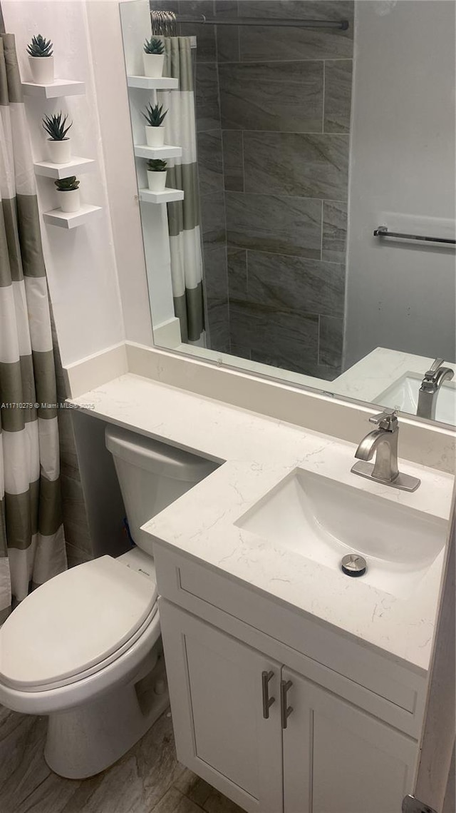 bathroom featuring walk in shower, vanity, and toilet