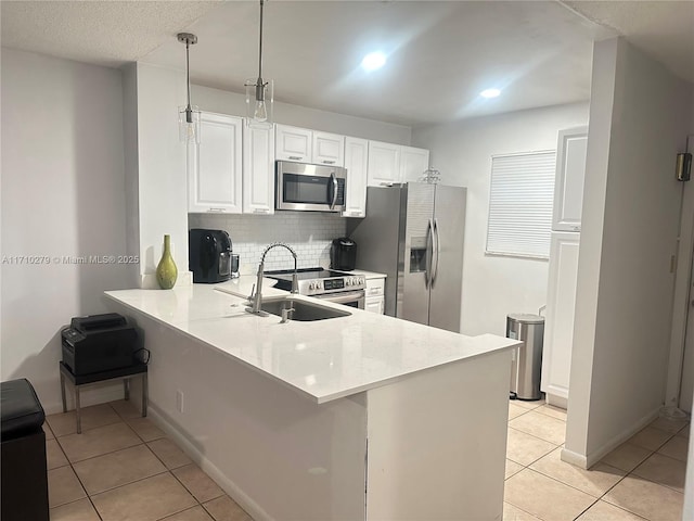 kitchen featuring light tile patterned floors, kitchen peninsula, and appliances with stainless steel finishes