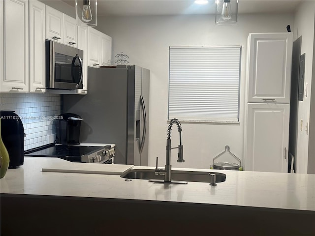 kitchen with tasteful backsplash, sink, white cabinets, and stainless steel appliances