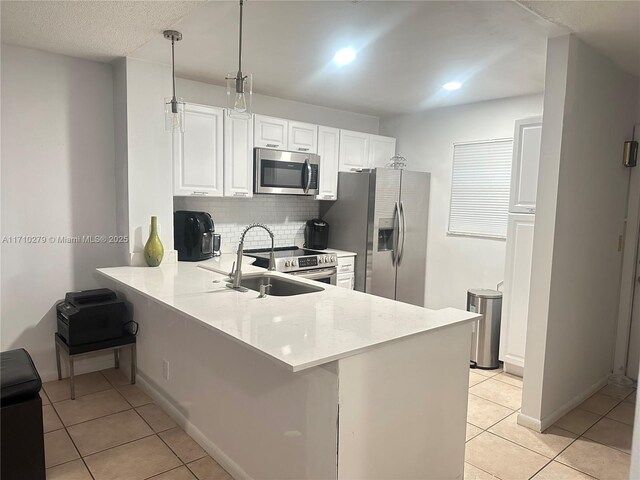 kitchen with kitchen peninsula, appliances with stainless steel finishes, and light tile patterned floors