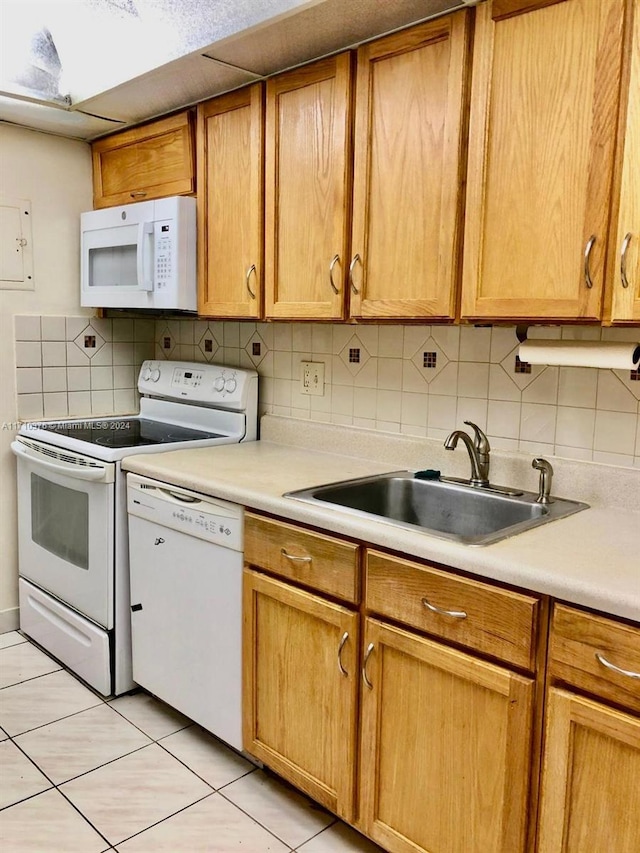 kitchen with sink, light tile patterned floors, white appliances, and backsplash