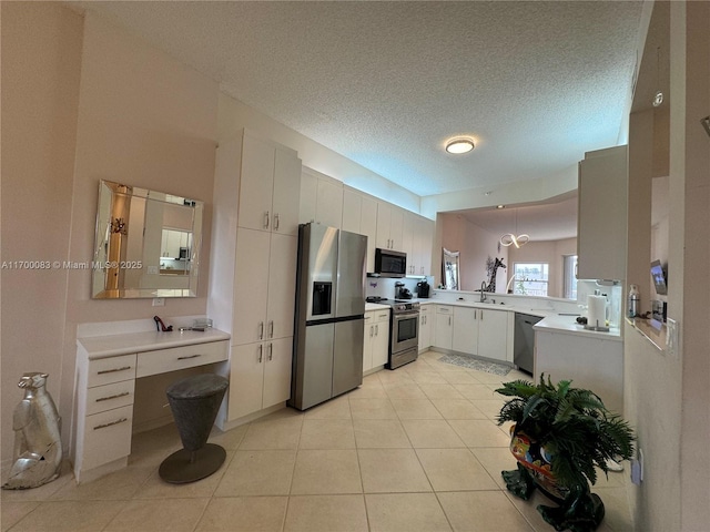 kitchen featuring white cabinets, sink, light tile patterned floors, a textured ceiling, and stainless steel appliances