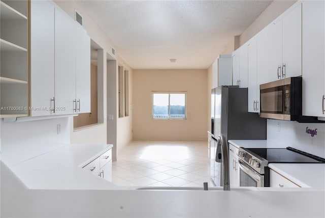 kitchen with white cabinetry, light tile patterned flooring, and appliances with stainless steel finishes