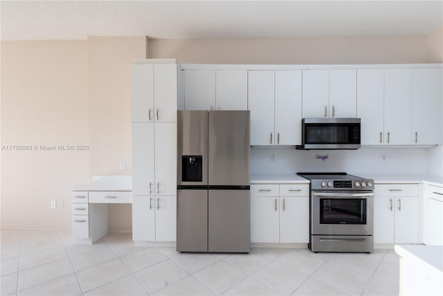 kitchen with light tile patterned floors, white cabinetry, a textured ceiling, and appliances with stainless steel finishes