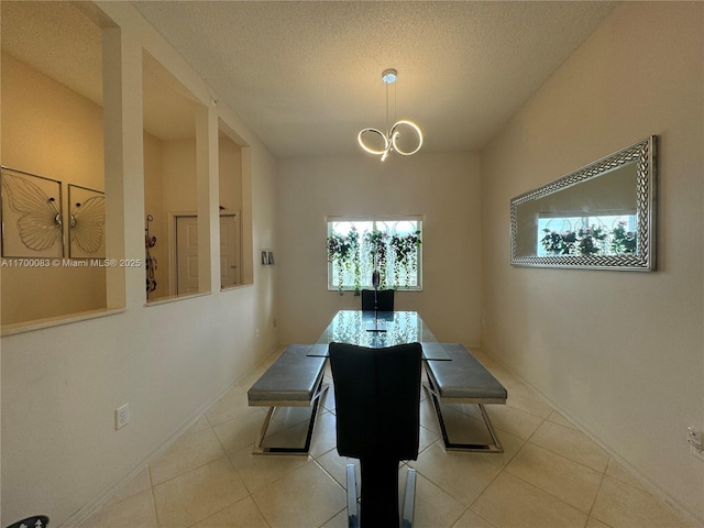 tiled dining space featuring a textured ceiling