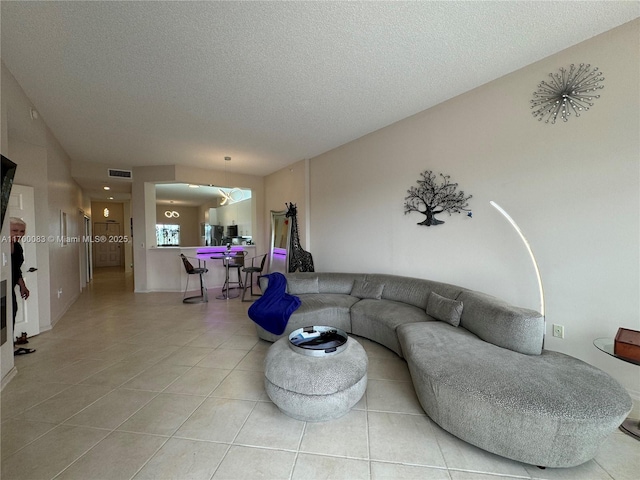 tiled living room featuring a textured ceiling