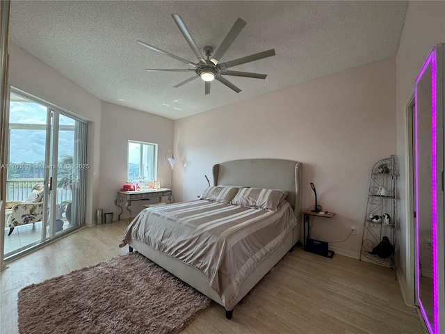 bedroom featuring access to outside, ceiling fan, a textured ceiling, and light wood-type flooring