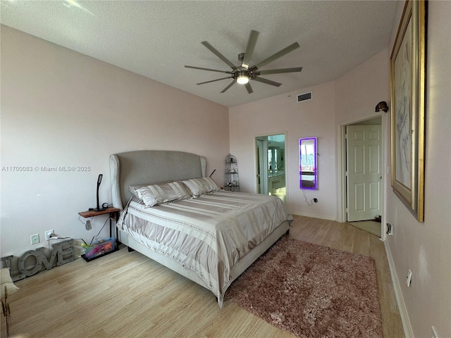 bedroom featuring a textured ceiling, light hardwood / wood-style floors, and ceiling fan