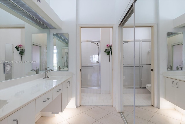 bathroom with tile patterned floors, toilet, vanity, and walk in shower