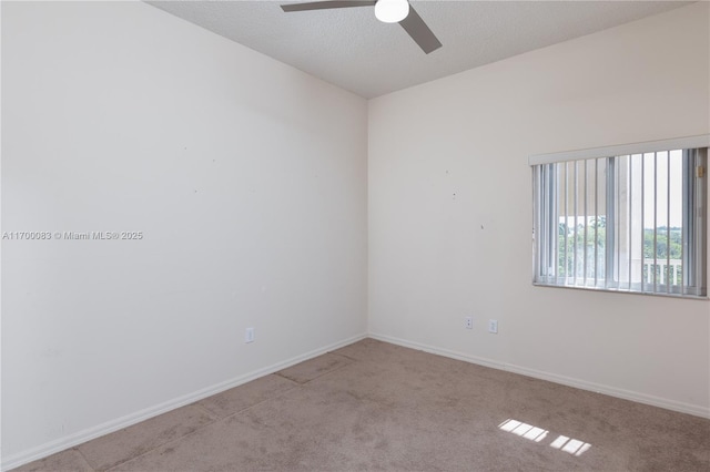 spare room featuring ceiling fan, light colored carpet, and a textured ceiling