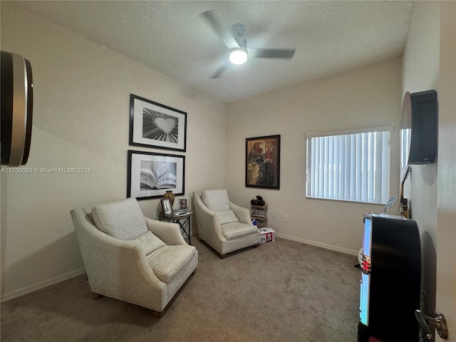 sitting room with ceiling fan, carpet, and a textured ceiling