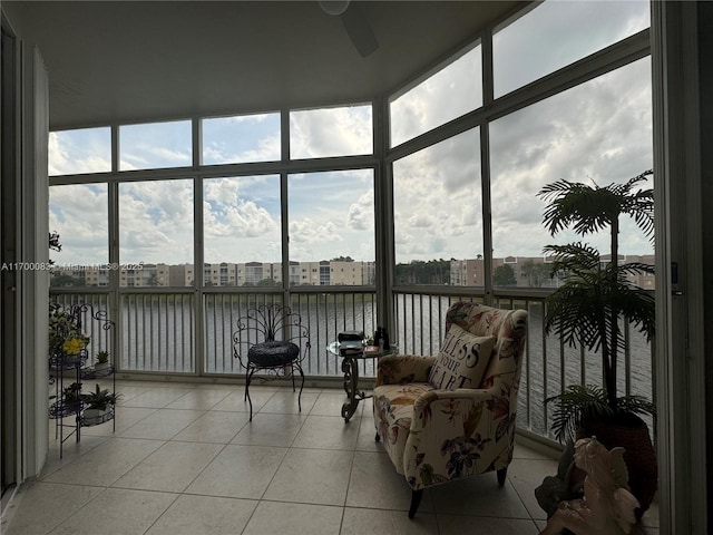 sunroom featuring a water view, plenty of natural light, and ceiling fan