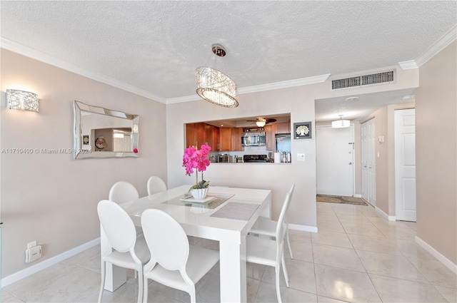 tiled dining space featuring ceiling fan, ornamental molding, and a textured ceiling