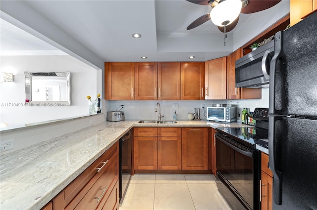 kitchen featuring backsplash, light stone counters, sink, black appliances, and light tile patterned flooring