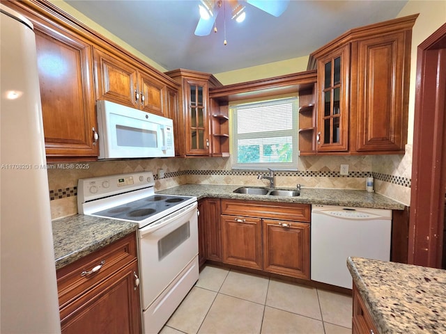 kitchen featuring light tile patterned flooring, sink, light stone counters, tasteful backsplash, and white appliances