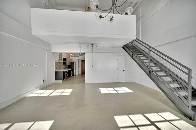 unfurnished living room featuring a chandelier