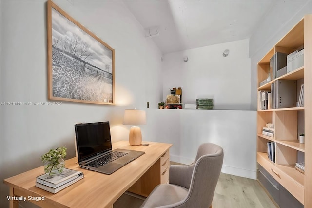 home office with light hardwood / wood-style flooring