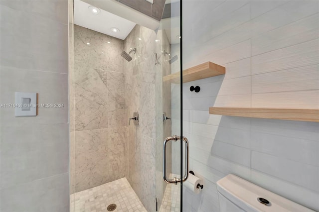 bathroom featuring tile walls, an enclosed shower, and toilet