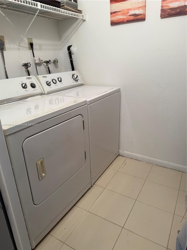 laundry area featuring washer and clothes dryer and light tile patterned flooring