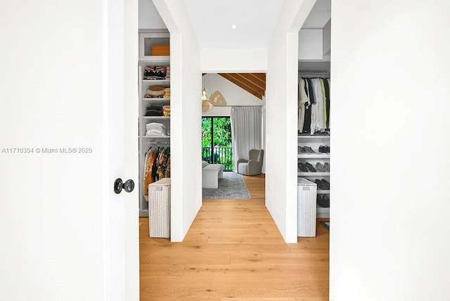 hall with light hardwood / wood-style flooring and lofted ceiling with beams