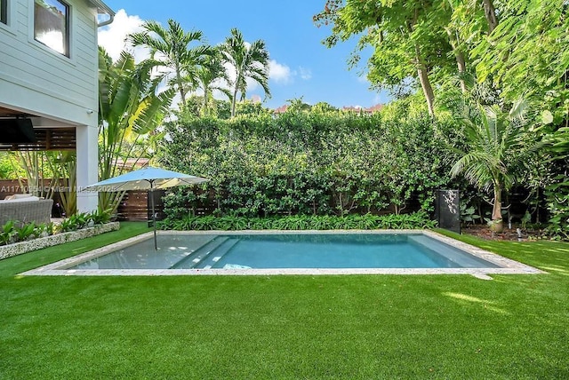 view of swimming pool featuring a lawn