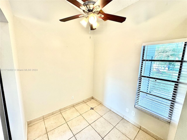 tiled empty room featuring ceiling fan