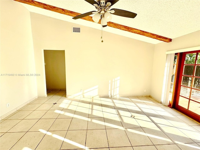 tiled empty room featuring vaulted ceiling with beams, ceiling fan, and a textured ceiling