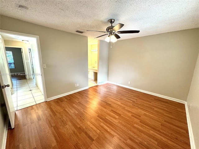 unfurnished bedroom featuring a textured ceiling, hardwood / wood-style flooring, and ceiling fan