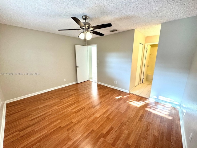 unfurnished room with a textured ceiling, light hardwood / wood-style flooring, and ceiling fan